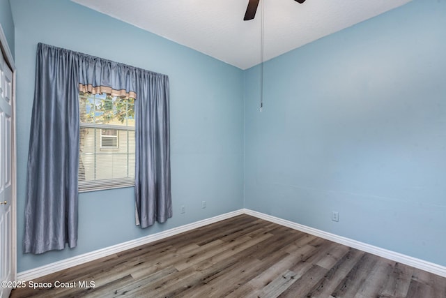 unfurnished room with wood finished floors, ceiling fan, and baseboards