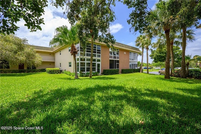 44 Vista Gardens Trl Unit 206, Vero Beach, FL 32962 - back of house with stucco siding and a lawn
