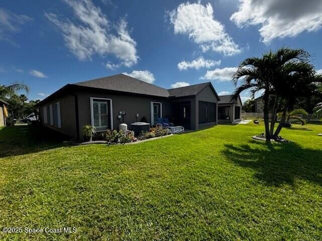 451 Dillard Dr SE, Palm Bay, FL 32909 - back of property featuring a yard, central air condition unit, and stucco siding