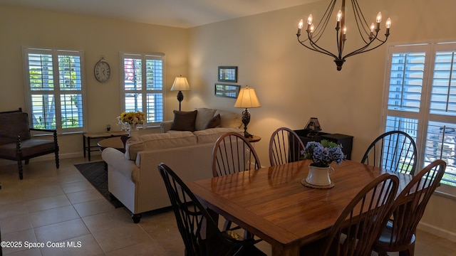 451 Dillard Dr SE, Palm Bay, FL 32909 - dining area featuring a chandelier, plenty of natural light, light tile patterned floors, and baseboards