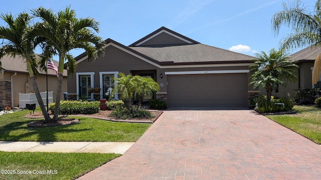 451 Dillard Dr SE, Palm Bay, FL 32909 - single story home with an attached garage, stucco siding, decorative driveway, a front yard, and a shingled roof