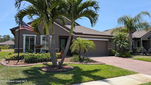 451 Dillard Dr SE, Palm Bay, FL 32909 - view of front of house with stucco siding, decorative driveway, a garage, and a front yard