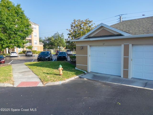 3848 Lexmark Ln Unit 307, Rockledge, FL 32955 - view of side of property with stucco siding, a shingled roof, and a lawn