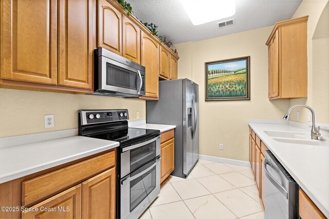 3848 Lexmark Ln Unit 307, Rockledge, FL 32955 - kitchen with appliances with stainless steel finishes, a sink, light countertops, and a textured ceiling