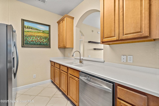 3848 Lexmark Ln Unit 307, Rockledge, FL 32955 - kitchen featuring stainless steel appliances, a sink, baseboards, arched walkways, and light marble finish flooring