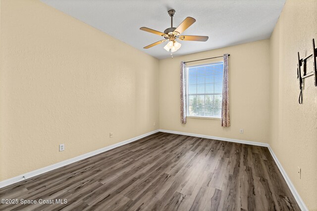 3848 Lexmark Ln Unit 307, Rockledge, FL 32955 - unfurnished room with dark wood finished floors, baseboards, ceiling fan, and a textured wall