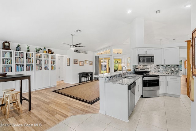 722 Hyannie St NE, Palm Bay, FL 32907 - kitchen with appliances with stainless steel finishes, a sink, a peninsula, a ceiling fan, and lofted ceiling