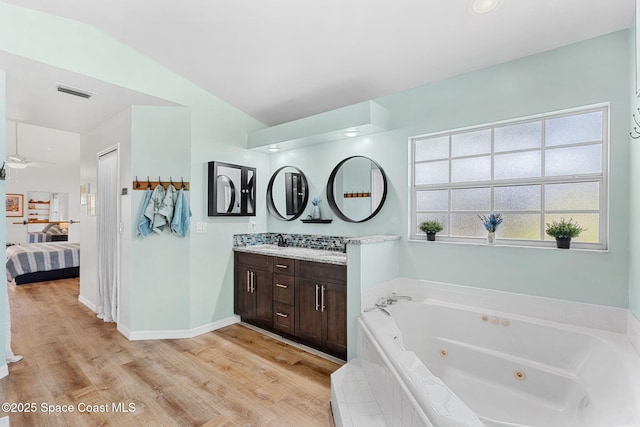 722 Hyannie St NE, Palm Bay, FL 32907 - ensuite bathroom featuring wood finished floors, vanity, and a tub with jets
