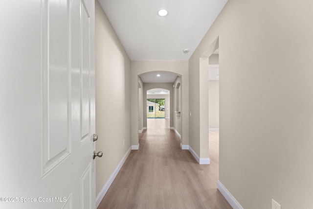 563 Holmes Ave NW, Palm Bay, FL 32907 - hallway featuring arched walkways, light wood-style floors, baseboards, and recessed lighting