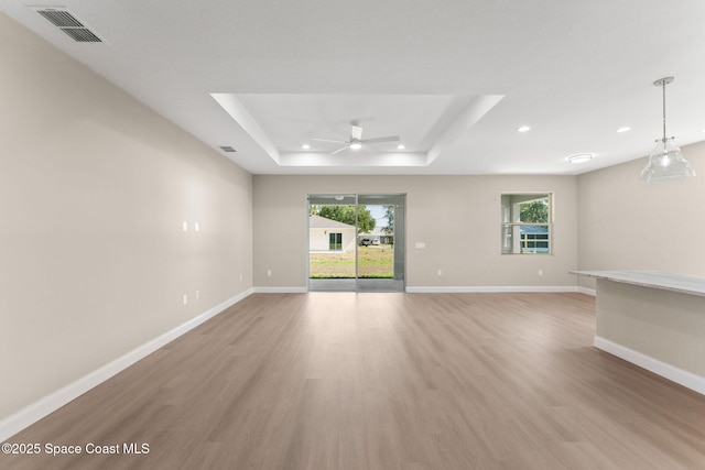 563 Holmes Ave NW, Palm Bay, FL 32907 - spare room featuring a tray ceiling, ceiling fan, light wood-style flooring, baseboards, and recessed lighting
