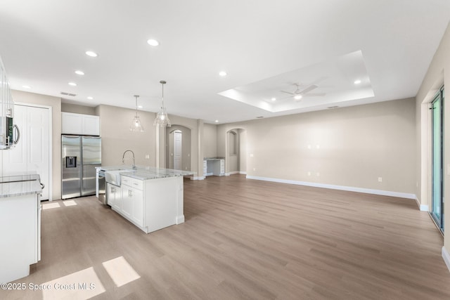 563 Holmes Ave NW, Palm Bay, FL 32907 - kitchen featuring appliances with stainless steel finishes, arched walkways, a ceiling fan, light wood-style flooring, and a sink