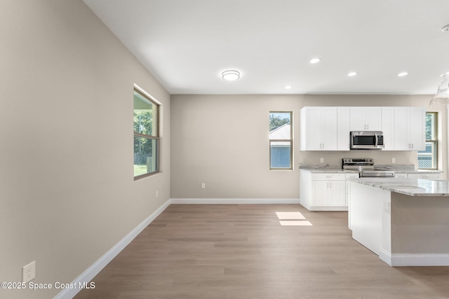 563 Holmes Ave NW, Palm Bay, FL 32907 - kitchen featuring stainless steel appliances, light wood-type flooring, white cabinets, baseboards, and recessed lighting