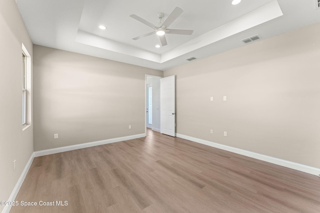 563 Holmes Ave NW, Palm Bay, FL 32907 - unfurnished room with a raised ceiling, recessed lighting, a ceiling fan, light wood-type flooring, and baseboards