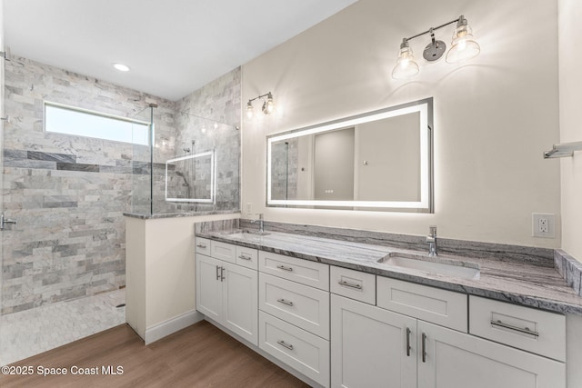 563 Holmes Ave NW, Palm Bay, FL 32907 - bathroom with walk in shower, wood finished floors, and double vanity