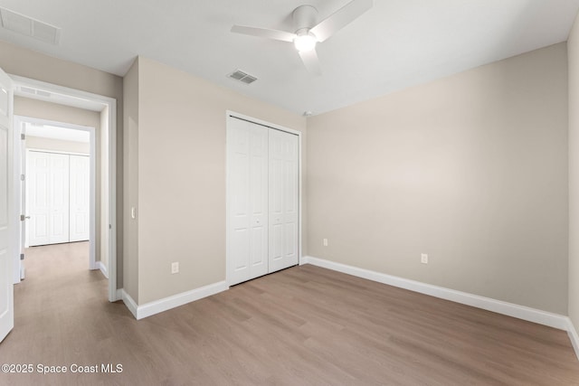 563 Holmes Ave NW, Palm Bay, FL 32907 - unfurnished bedroom with light wood finished floors, baseboards, a closet, and a ceiling fan