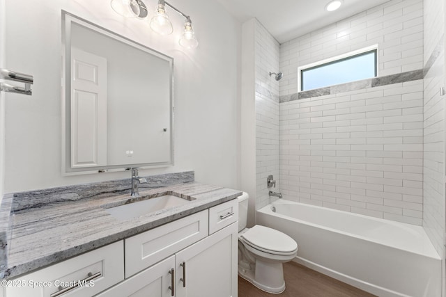 563 Holmes Ave NW, Palm Bay, FL 32907 - bathroom with toilet, washtub / shower combination, vanity, and wood finished floors