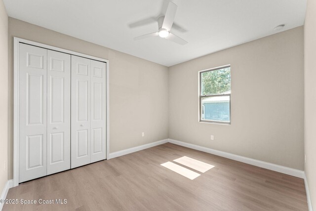 563 Holmes Ave NW, Palm Bay, FL 32907 - unfurnished bedroom featuring light wood-type flooring, a closet, and baseboards