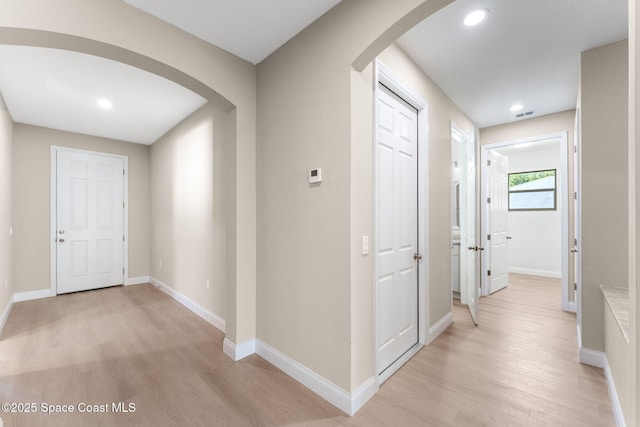 563 Holmes Ave NW, Palm Bay, FL 32907 - hall with arched walkways, light wood-style flooring, baseboards, and recessed lighting