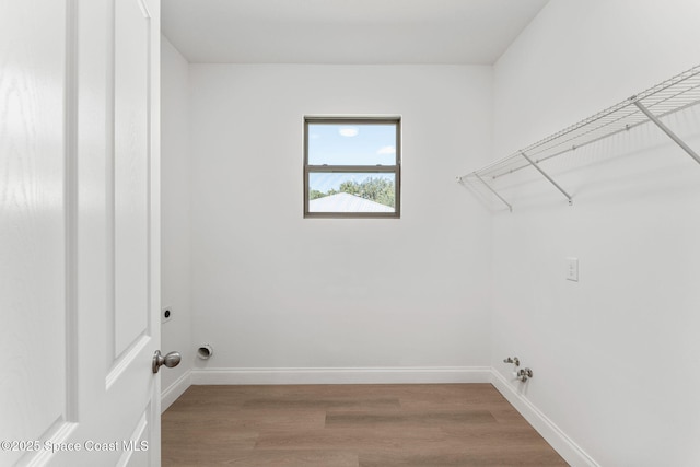 563 Holmes Ave NW, Palm Bay, FL 32907 - clothes washing area featuring wood finished floors, baseboards, gas dryer hookup, and hookup for an electric dryer