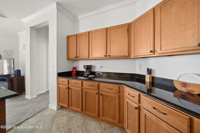 1662 Orsi Pl, West Melbourne, FL 32904 - kitchen with crown molding, brown cabinets, baseboards, dark stone counters, and light colored carpet