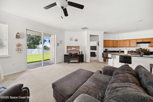 1662 Orsi Pl, West Melbourne, FL 32904 - living room featuring light carpet, crown molding, a ceiling fan, and baseboards