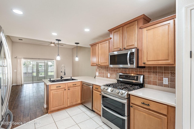 1536 Grand Isle Blvd, Melbourne, FL 32940 - kitchen featuring appliances with stainless steel finishes, a sink, a peninsula, a ceiling fan, and tasteful backsplash