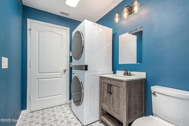 1536 Grand Isle Blvd, Melbourne, FL 32940 - bathroom with estacked washer and dryer, toilet, vanity, baseboards, and tile patterned floors