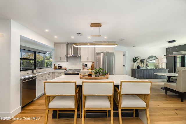3204 Nottingham Ln, Cocoa, FL 32926 - kitchen featuring stainless steel appliances, wall chimney range hood, a sink, light countertops, and decorative backsplash