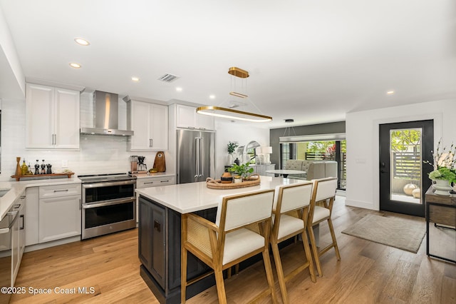 3204 Nottingham Ln, Cocoa, FL 32926 - kitchen with appliances with stainless steel finishes, wall chimney exhaust hood, light countertops, white cabinets, and backsplash