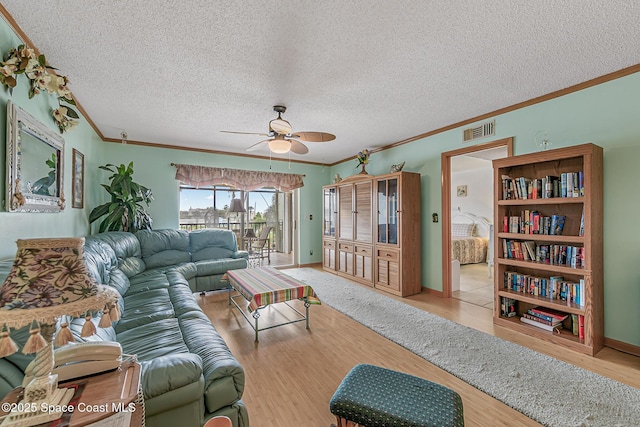 3165 N Atlantic Ave Unit C206, Cocoa Beach, FL 32931 - living room with ornamental molding, ceiling fan, wood finished floors, a textured ceiling, and baseboards