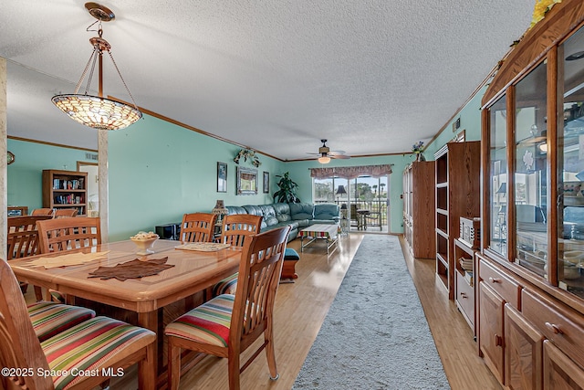 3165 N Atlantic Ave Unit C206, Cocoa Beach, FL 32931 - dining space featuring a textured ceiling, crown molding, light wood-style flooring, and ceiling fan