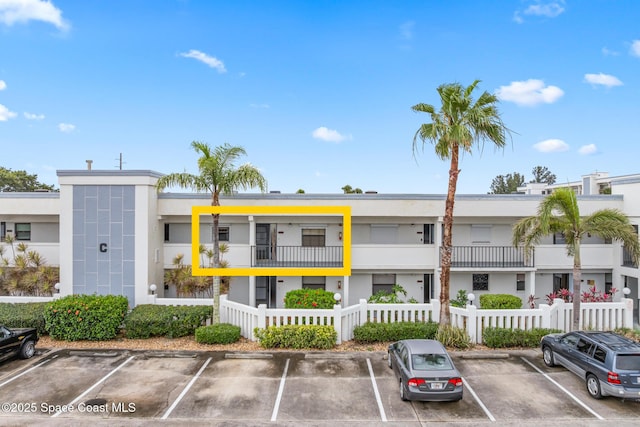 3165 N Atlantic Ave Unit C206, Cocoa Beach, FL 32931 - view of property with uncovered parking and a fenced front yard