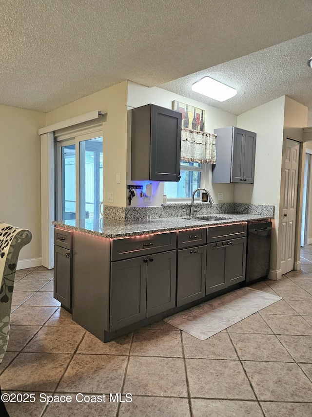 6630 Cecil Rd, Cocoa, FL 32927 - kitchen featuring dishwashing machine, a textured ceiling, gray cabinetry, plenty of natural light, and light tile patterned floors