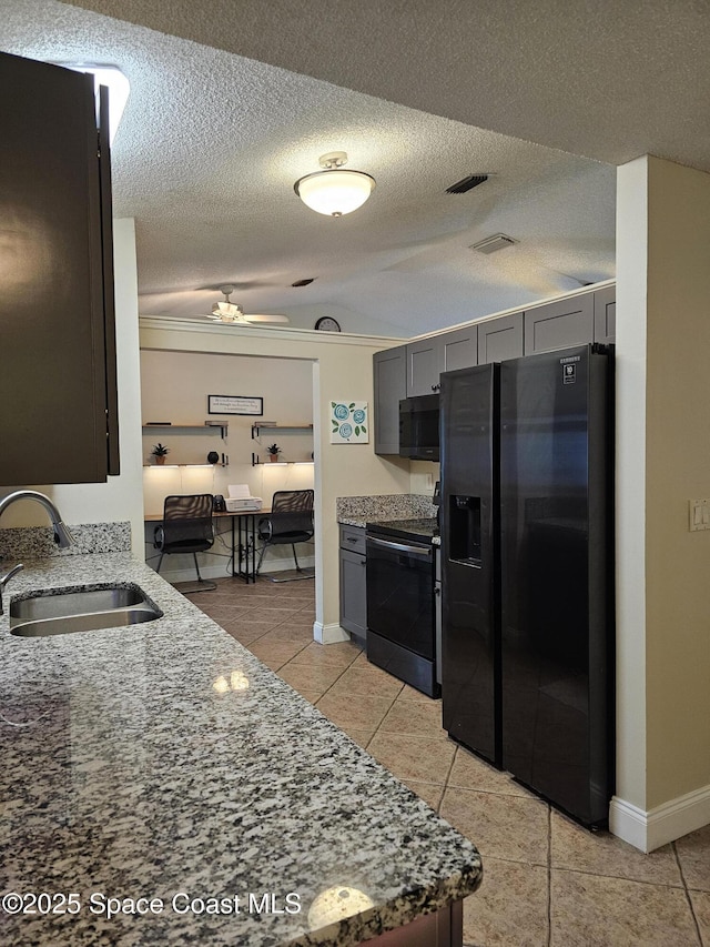 6630 Cecil Rd, Cocoa, FL 32927 - kitchen featuring black refrigerator with ice dispenser, stove, light tile patterned floors, light stone counters, and a textured ceiling