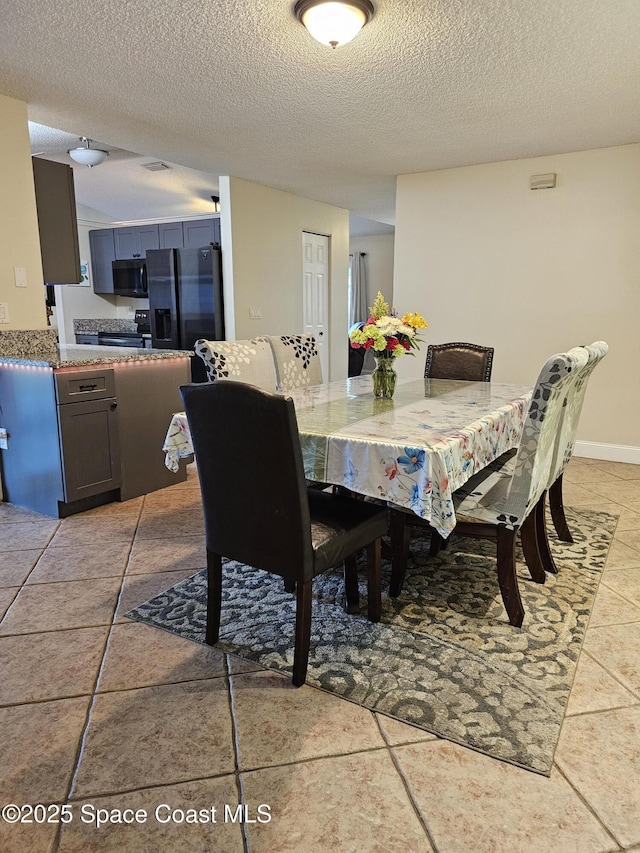 6630 Cecil Rd, Cocoa, FL 32927 - dining area featuring a textured ceiling and light tile patterned floors