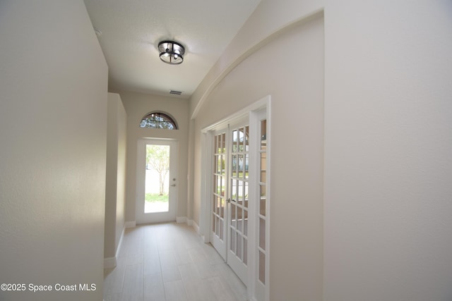 doorway with baseboards and light wood finished floors