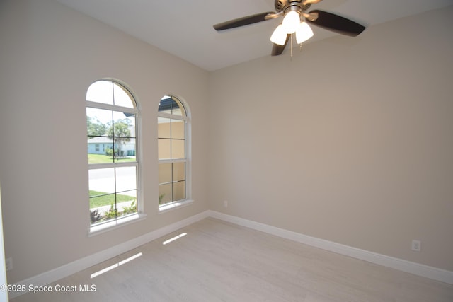 empty room featuring plenty of natural light, light wood finished floors, and a ceiling fan