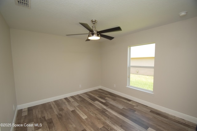 unfurnished room with dark wood-type flooring, baseboards, ceiling fan, and a textured ceiling