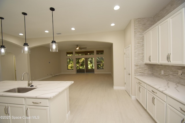 kitchen with a sink, a ceiling fan, baseboards, recessed lighting, and white cabinets