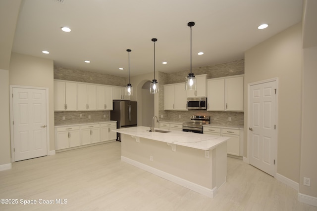 kitchen featuring appliances with stainless steel finishes, backsplash, light wood finished floors, white cabinetry, and recessed lighting