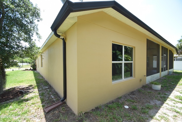 view of home's exterior with stucco siding and a sunroom