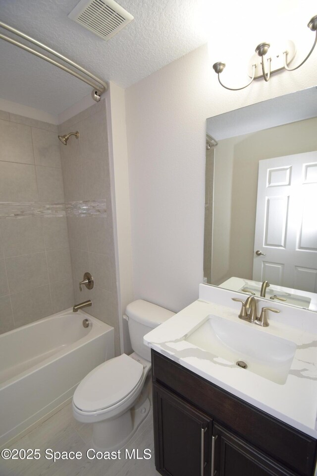bathroom with toilet, tub / shower combination, vanity, and a textured ceiling