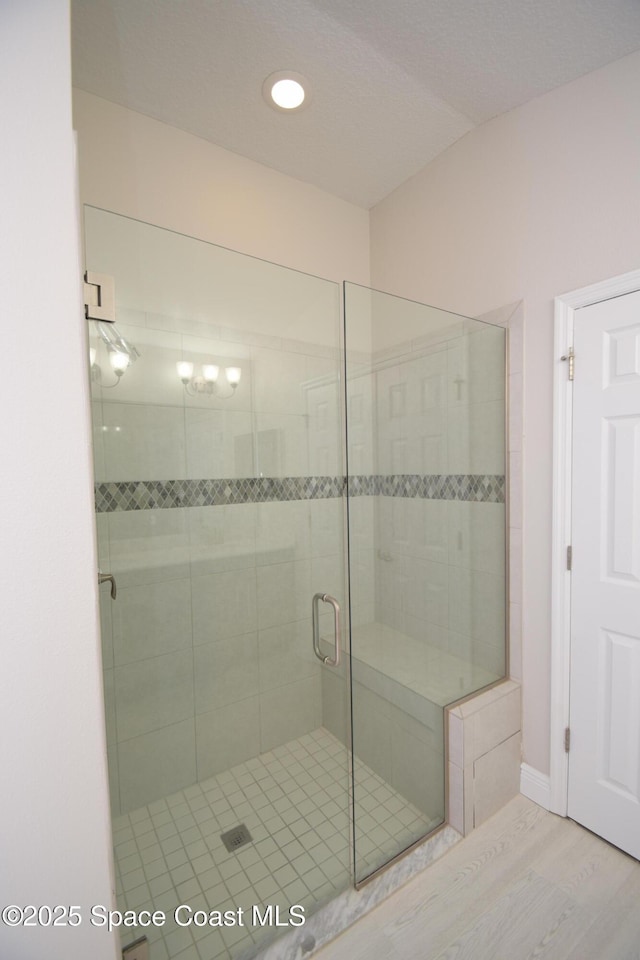 full bath with a shower stall, wood finished floors, and baseboards