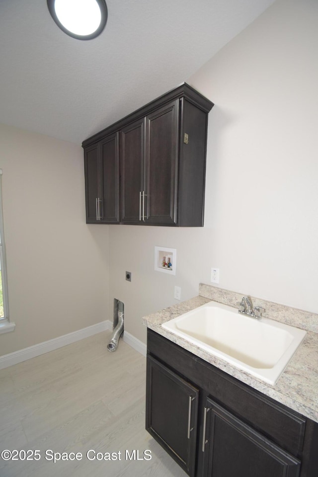 washroom with hookup for a washing machine, light wood-type flooring, cabinet space, hookup for an electric dryer, and baseboards