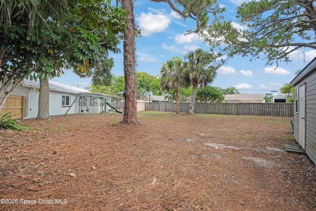 fenced backyard featuring a playground