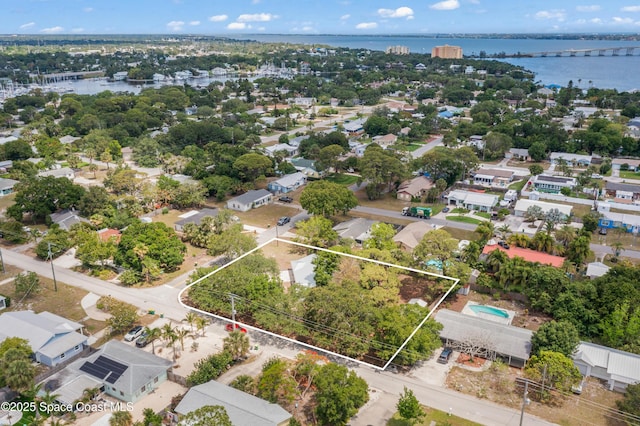 aerial perspective of suburban area featuring a nearby body of water and property boundaries highlighted
