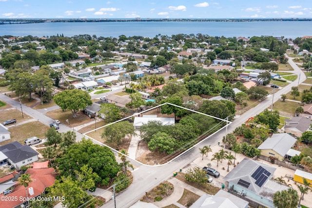 aerial perspective of suburban area with a large body of water and property boundaries highlighted