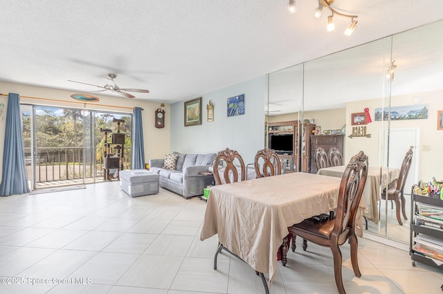 dining space featuring ceiling fan, light tile patterned floors, and a textured ceiling