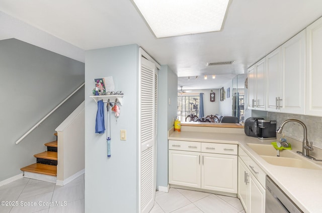 kitchen featuring a sink, light tile patterned flooring, light countertops, and white cabinetry