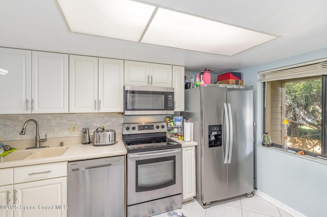 kitchen featuring appliances with stainless steel finishes, a sink, and white cabinets